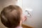 Small child is looking at an electrical outlet at home. Safety of children