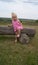 Small child next to the wooden log