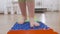 A small child in the nursery walks barefoot on a massage mat, stepping on a prickly surface