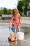 Small child at playground in park playing with water and toys. Little girl at splash pad in summer