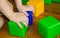 A small child playing with colorful cubes builds a tower, the concept of early education preparation for the development of the