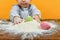 A small child sculpts Easter eggs from flour