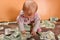 A small child sits on a heap with money. The concept of wealth and financial independence
