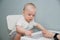 A small child sits at a white table and plays in a children`s lotto. The kid studies animals on cards, plays a board game