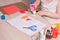 a small child smears paper with glue, children`s safe scissors and colored paper on the table