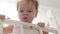 Small child stands on his feet in baby bed.