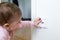 Small child touches an electrical outlet at home. Safety of children