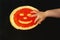 A small child touches a fried pancake with red caviar. a smiling face made from fish ROE on a yellow pancake.