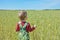 Small child in a wheat field stands with his back to the viewer. little child walks in a wheat field. a little boy in a wheat