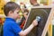 Small child wipes the chalk board.