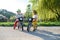 Small children with face masks playing outdoors with bike, coronavirus concept.