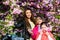 Small children and mother in spring flower. happy sisters in cherry flower. Sakura bloom. family summer. Natural beauty