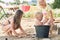 Small children play in the sand in the yard of their house in the summer.