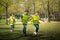 Small children playing football outdoors in city park, learning group education concept.