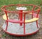 A small children`s carousel on the playground is made of metal a