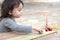 a small children& x27;s hand points to one toy car among a multitude of cars on a wooden red-yellow table