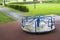 A small children`s old carousel after the rain. Playground for children games old carousel. Blue knobs, white floor with peeling