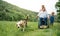 Small children with senior grandparents and dog on a walk on meadow in nature.