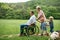 Small children with senior grandparents and dog on a walk on meadow in nature.