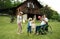 Small children with senior grandparents in wheelchair playing with a ball in garden.