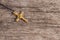 Small Christian golden cross on rustic wooden background