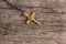 Small Christian golden cross on rustic wooden background