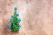 Small Christmas tree with blue wooden stars on a beige rustic background. Top view, flat lay, copy space