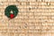 Small Christmas wreath on a cedar shingle wall