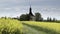 Small church, baroque chapel with belfry at field with oilseed rape