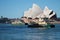 Small city ferry in front of the Sydney Opera House, waterfront and blue sky, Sydney