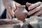 Small clay vase and hands of working potter