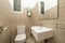 Small cloakroom with white porcelain sink, frameless mirror