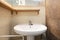 small cloakroom with white porcelain sink with wooden shelves