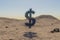 small cloud dollar symbol in large desert environment with sand dunes, hills and rocks laying arround business profit concept 3D