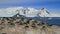small colony of AdÃ©lie penguins in background of mountains and the ocean on the west coast of the Antarctic Peninsula