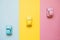 Small color toy cars on a yellow, pink and blue background. Business competition, winners and losers. Finish line