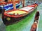 A small colored gondola parked beside one of the canals of Venice