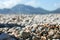 Small colored sea pebbles and shells against the blurred mountain and sky