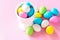 Small colorful candy eggs in the stand. Easter celebrate concept. Pink background