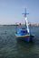 Small colorful fishing boat boat moored in Crete with mast and furled sail