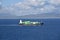 Small container ship sailing near sea coast close to Gibraltar.