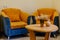 Small corner of a hotel room with two armchairs and an oval wooden table