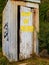 Small corrugated iron outside toilet with door sign