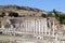 Small and cosy ancient roman theatre with the ruins of temple with row of columns in archaeological site Pergamon in Turkey