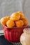 Small cottage cheese doughnuts (castgnole) served on a red bowl