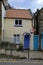 Small cottage situated between two large buildings in Robin Hoods Bay, North Yorkshire, UK