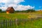 Small country house, meadow and wooden fence