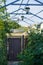 Small courtyard of privat house with wrought-iron railings gates wicket, grille for grapes and beautiful lanterns