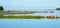 A small creek on the bay fenced with granite stones and grass. A clear summer morning