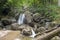 Small creek with many waterfalls in the middle of forest